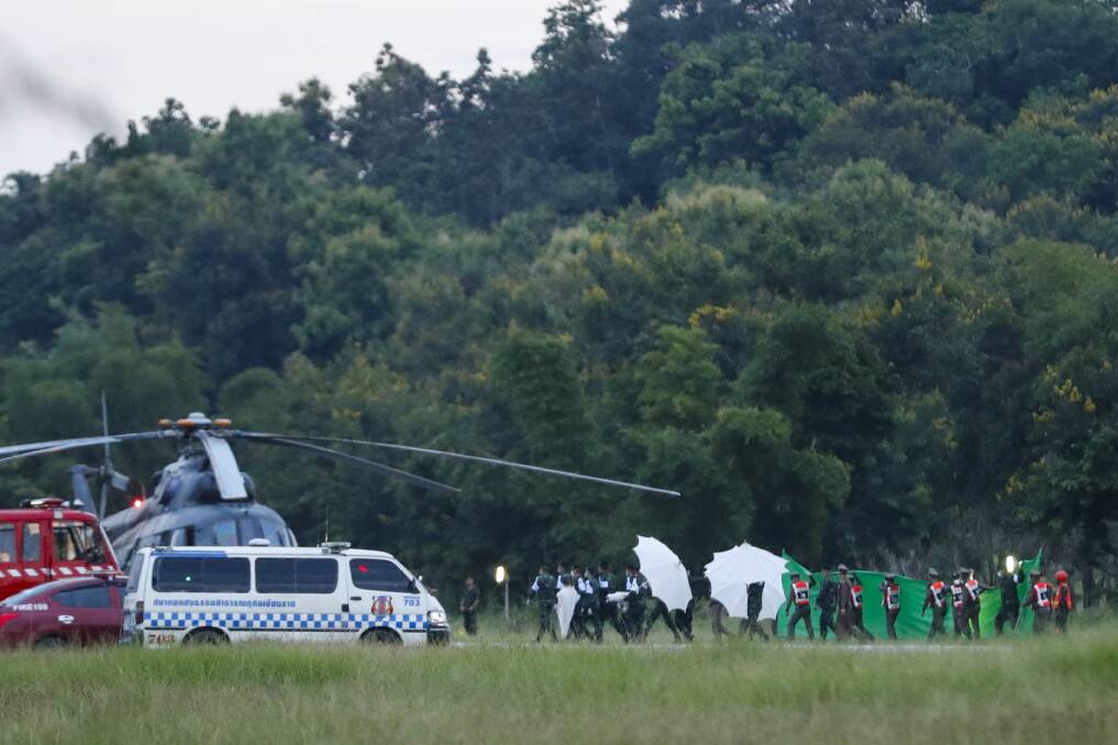 An emergency team rushes to a helicopter believed to be carrying one of the rescued boys from the flooded cave. Photo: AP
