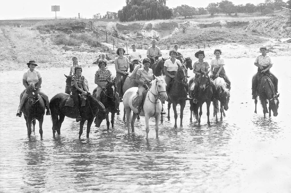 Bobby Llewellyn (far left) with participants at her horse riding school, including her daughter Jan (far right) crossing the Molonglo river near Acton, circa 1958. Photo: Gayle Mooney and sunkenstories.com