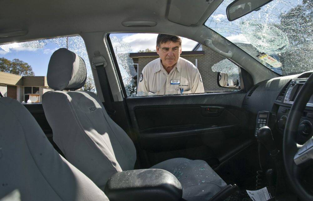 Peter Galvin looks at a new Toyota Hilux whose windows were broken and the tyres slashed. Photo: Elesa Kurtz