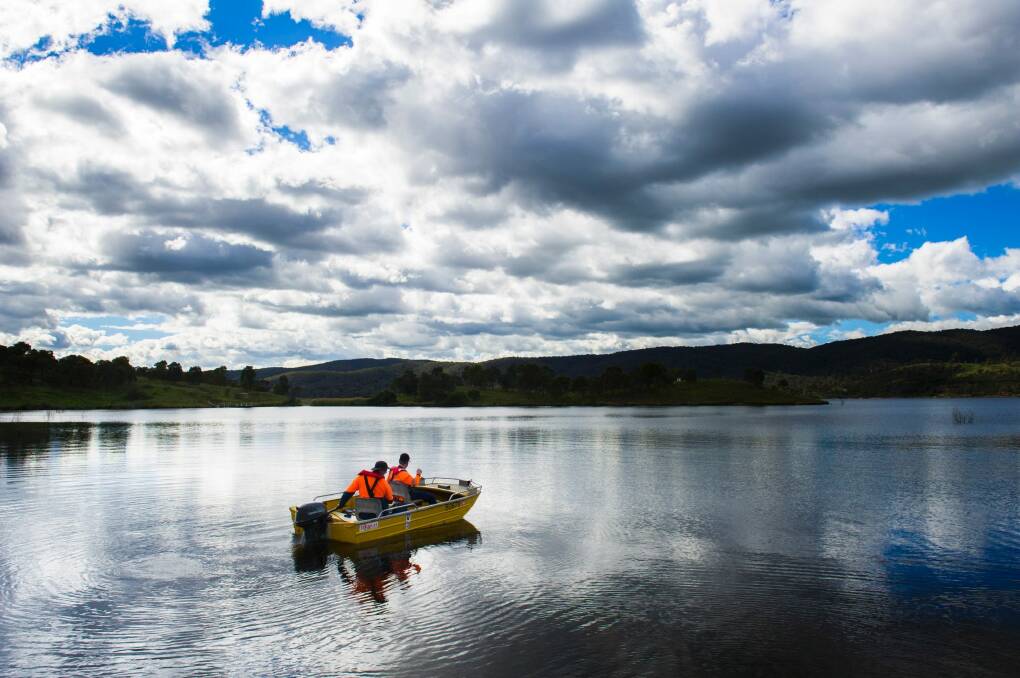 Workers on Googong Dam test the water quality in April.  Photo: Rohan Thomson
