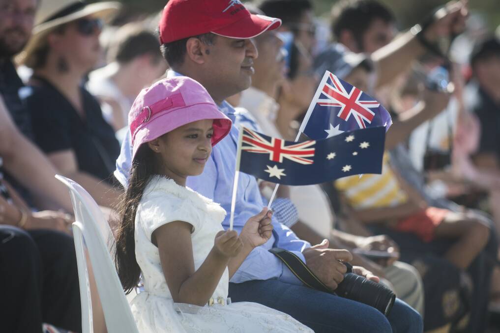 Ria Francis waves the Australian flag at the national citizenship ceremony in Commonwealth Park on Saturday morning. Photo: Dion Georgopoulos