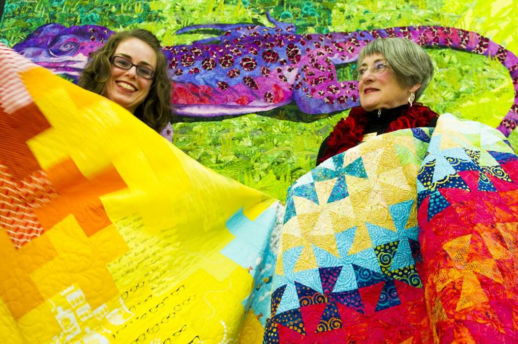 Canberra Quilters member Gemma Jackson, left, and president Helen Rose with some of the beautiful quilts. Photo: Jay Cronan