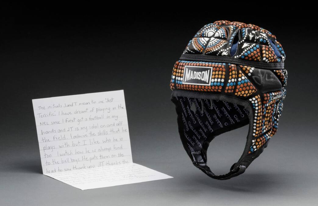 NRL Johnathan Thurston chose a letter from a young fan and his NRL Allstars head gear to go in the exhibition. Photo: Jason McCarthy
