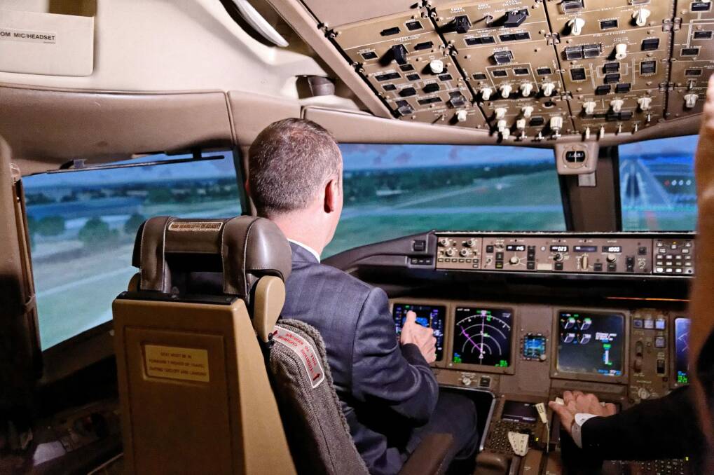 Chief Minister Andrew Barr controlling a simulated Boeing 777 flight out of Changi Airport. Photo: Andrew West