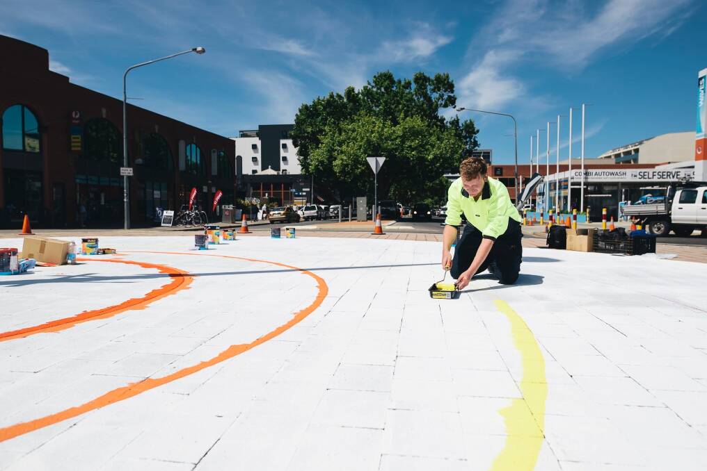 A painter prepares the roundabout for volunteers to paint this week. Photo: Rohan Thomson