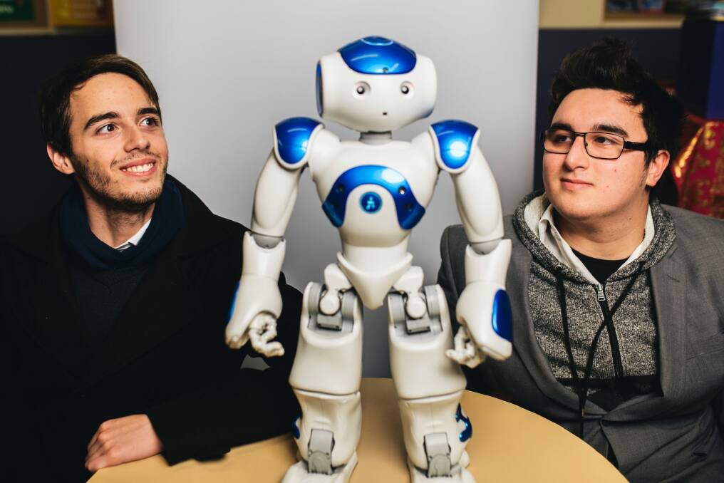 Connor Costanzo and Christopher Goddard with Leo the robot at Caroline Chisholm School. They are part of a team that has programmed the robot to help children with autism. Photo: Rohan Thomson