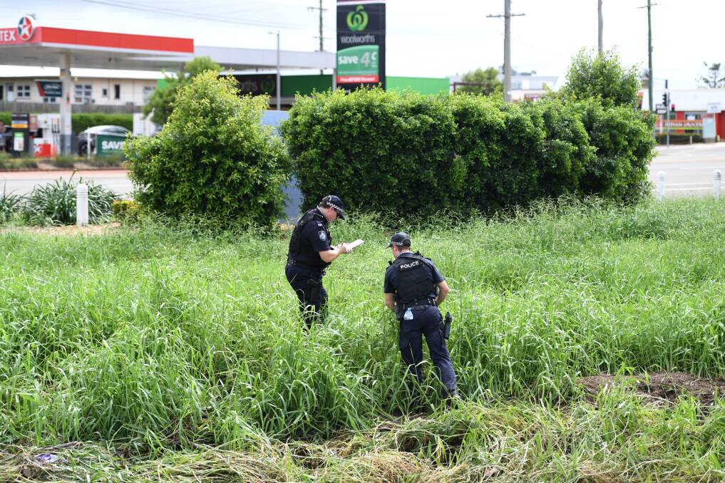 Police examine the scene where two bodies were found in a drain behind the Aitkenvale Library in Townsville. Photo: Dan Peled - AAP