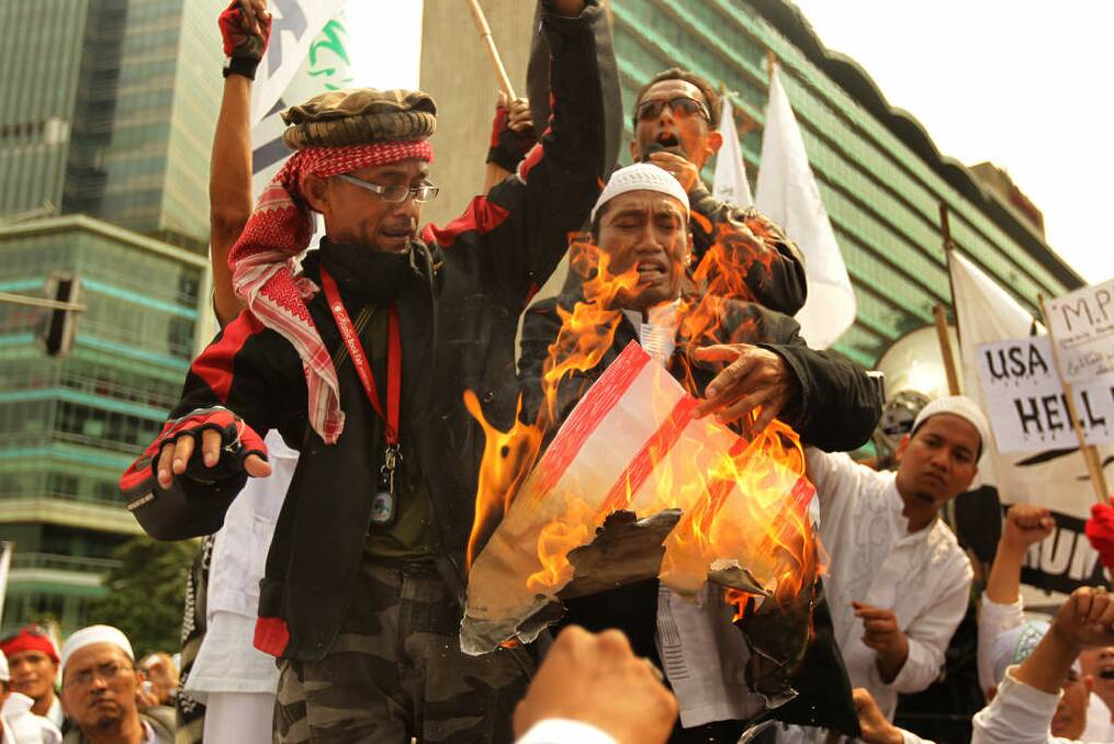 Protesters from Indonesia's hardline Islamic Defenders Front burn a poster of a US flag in 2012 to protest against the movie <i>Innocence of Muslims</i>. Photo: Kate Geraghty