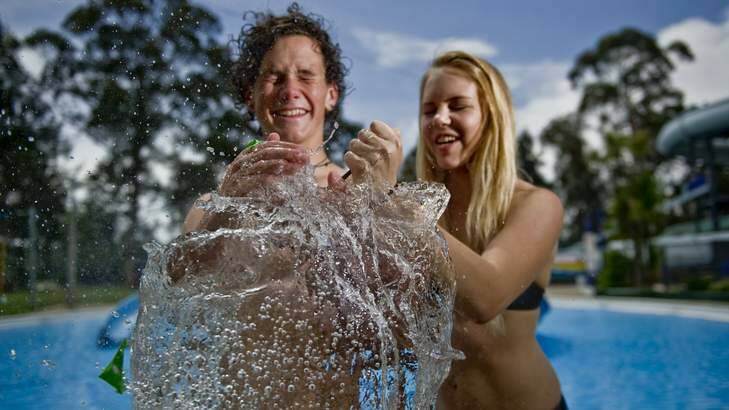 Canberra High year 10 students Jeremy Bradbury and Triska Hoelzl escape the heat at the Big Splash water park with water filled balloons. Photo: Jay Cronan