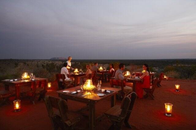 Tali Wiru is an intimate small group dining experience by candlelight atop a desert sand dune. Photo: Voyages Indigenous Tourism Australia