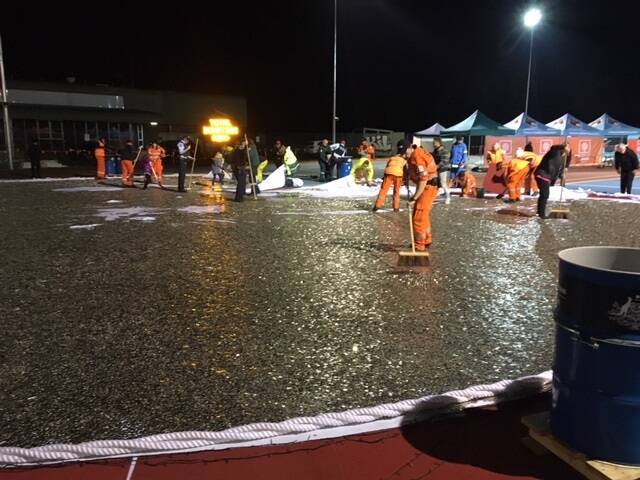 Emergency services workers and Love Your Sister volunteers clean up the coins on Wednesday night.  Photo: Supplied