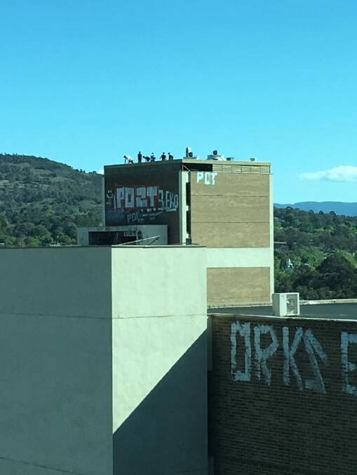People on the roof of the abandoned Woden building on Monday afternoon. Photo: Supplied