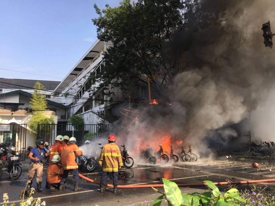 Firefighters try to extinguish a blaze following a blast at the Pentecost Church Central Surabaya (GPPS) in Surabaya. Photo: Indonesia Out