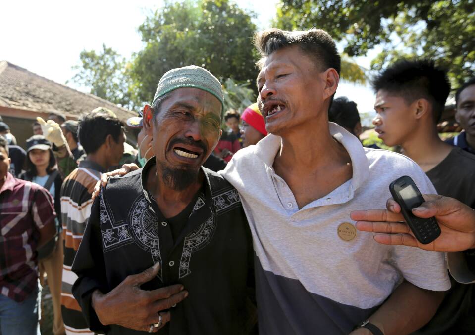 Relatives react as rescue teams recover the bodies of victims killed in an earthquake in North Lombok. Photo: AP