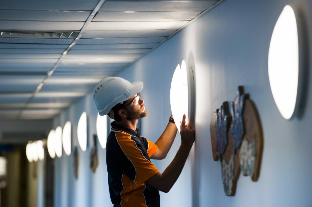 Canberra Hospital mechanical supervisor Sam Bryant fitting some of the new LED light bulbs throughout the hospital.  Photo: Elesa Kurtz