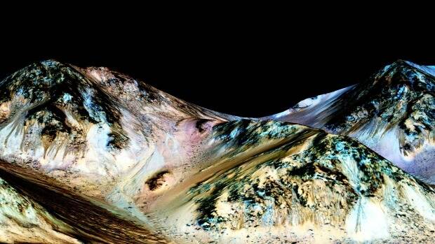 NASA says dark, narrow streaks flowing downhill on Mars were almost certainly formed by flowing water. Photo: NASA