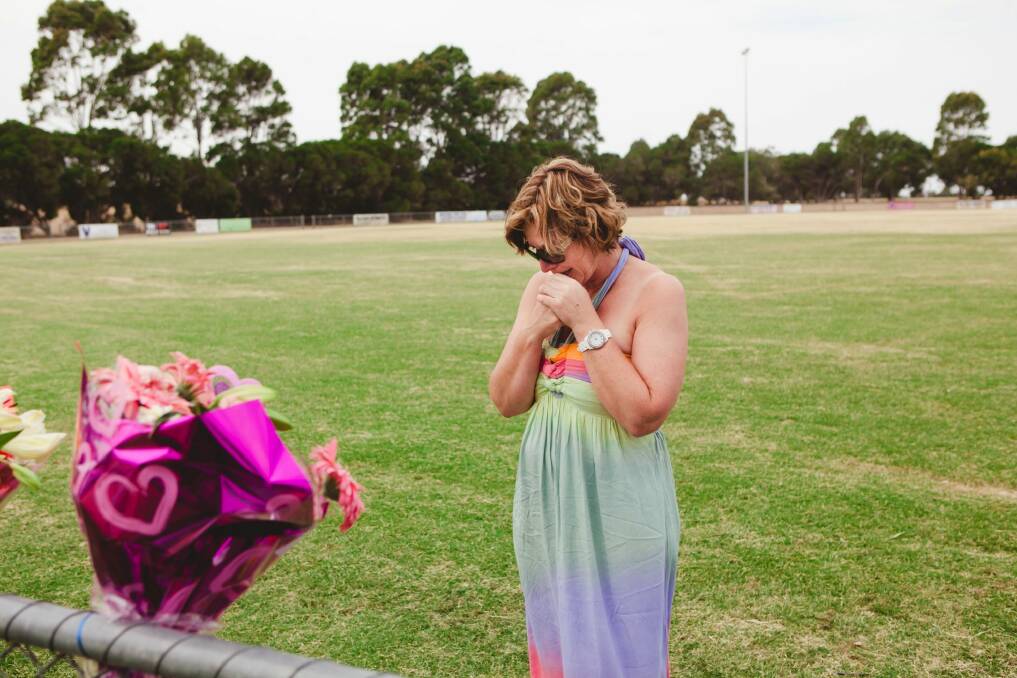 Luke Batty's mother, Rosie, at Tyabb oval reading cards well wishers left following the death of her son in early 2014. Photo: James Boddington