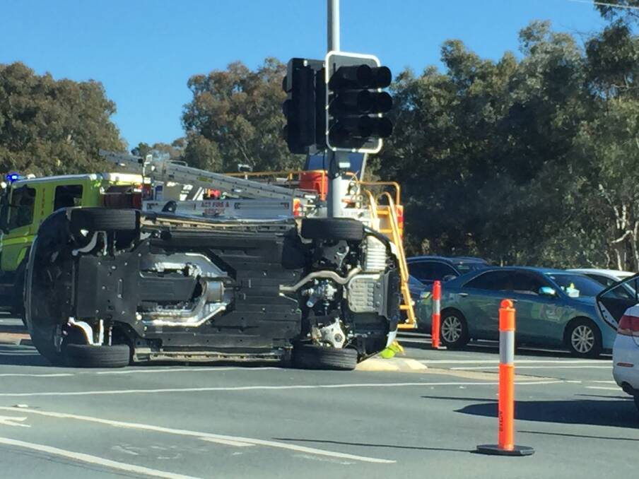 A car rests on its side at the intersection of Hindmarsh Drive and Yamba Drive on Sunday afternoon. Photo: Sitthixay Ditthavong