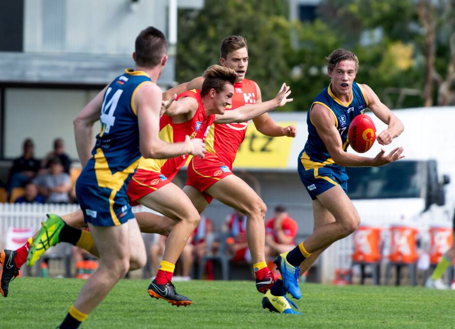 Canberra Demons player Jarrod Osborne, far right, about to pass to Donald Roberts, left, at Alan Ray Oval in Ainslie on Saturday. Photo: Elesa Kurtz