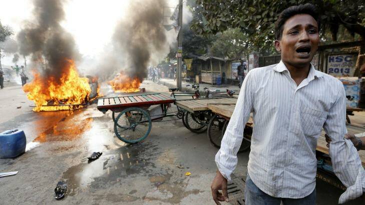 Devastated: A man cries after Jamaat-e-Islami party activists torched his vehicle. Photo: Reuters