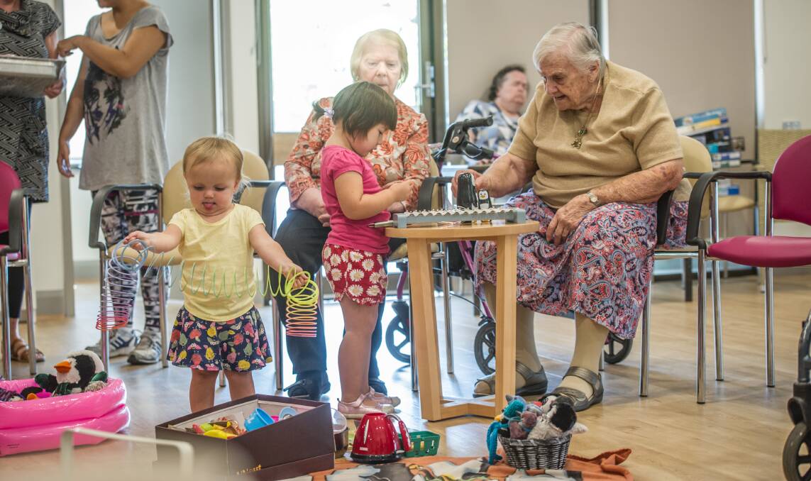 Judy Baker  plays with Lily Rossiter,3, while Gemma Woods, 22 months, (left) plays.  Photo: Karleen Minney