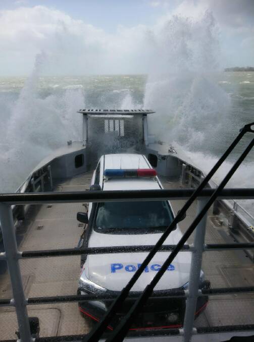 Queensland police vehicle copping a spray from Tropical Cyclone Oma on the way to North Stradbroke Island on Friday. Photo: Queensland Police Service