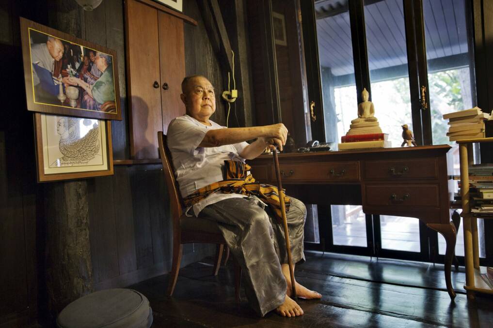 Sulak Sivaraksa, who has been charged or arrested five times under Thailand's lese-majeste law, at home in Bangkok. To the left is a photo of Sulak with the late king, Bhumibol Adulyadej. Photo: New York Times