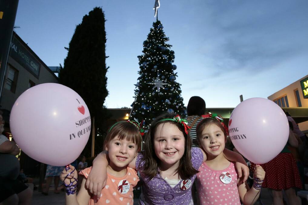 From left, Ava Kenningham, 5, Madison Lloyd, 7, and Olivia Kenningham, 5, all of Queanbeyan, in front of the Christmas tree in Crawford Street. Photo: Jeffrey Chan