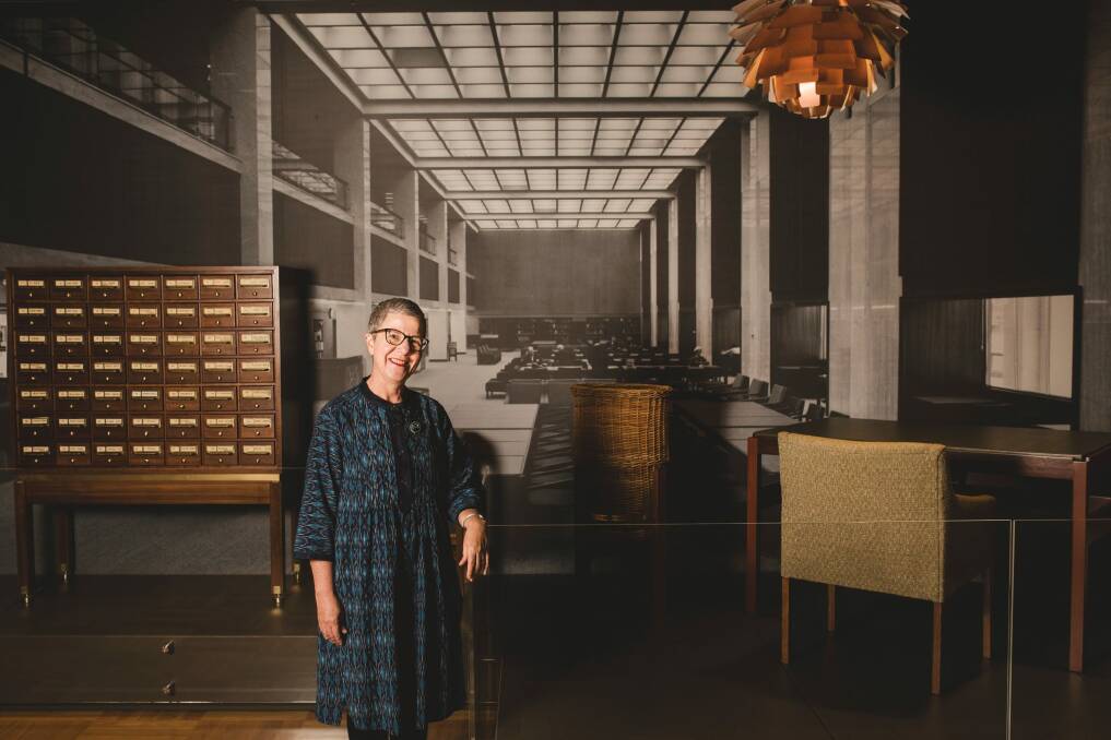 Director-General of the National Library of Australia, Dr Marie-Louise Ayres poses in front of a display of Fred Ward furniture representing a reading room from the 1960s. Photo: Jamila Toderas