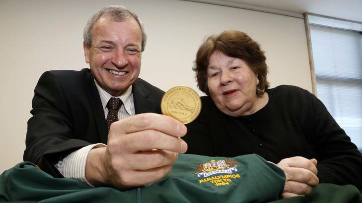 President of the Australian Paralympic Committee Greg Hartung has a look at the uniforms and medals donated to the Australian Paralympic Committee by Australia's first female Paralympian Daphne Hilton. Photo: Jeffrey Chan