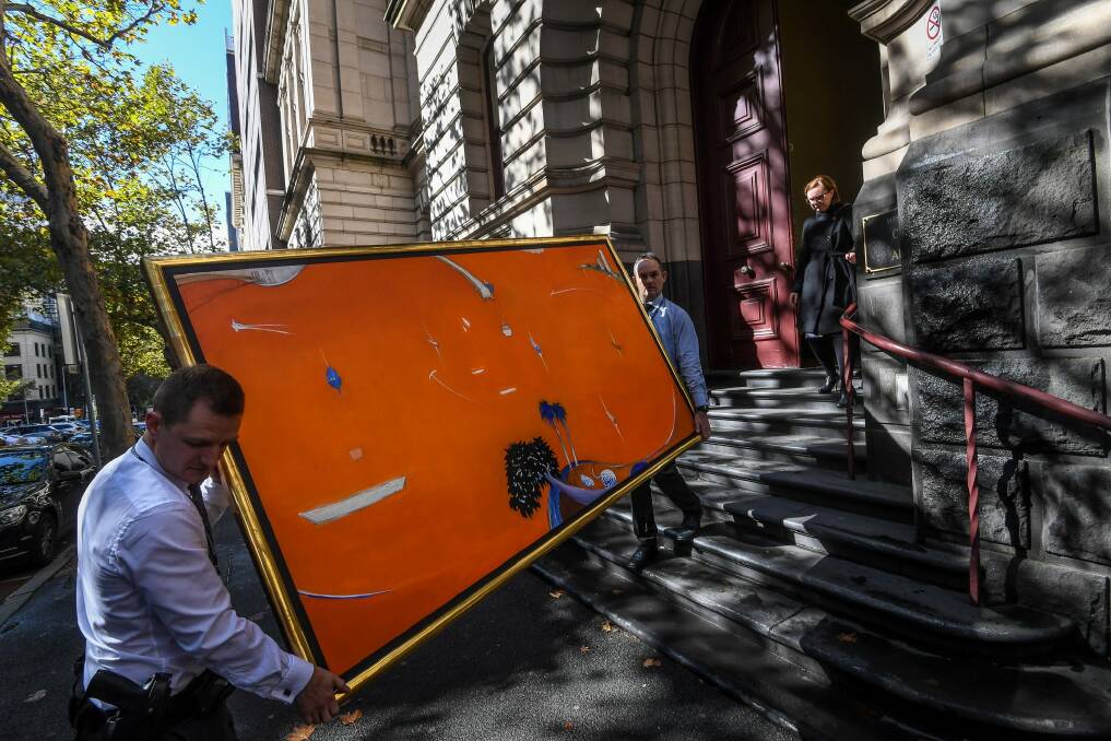 Brett Whiteley's 'Orange Lavender Bay' is carried from the court after Gant and Aman's appeal was heard. Photo: Justin McMacus