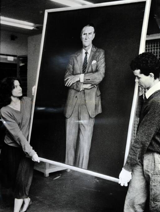 The disliked portrait being moved by National Gallery staffers Sara Kelly and Tim Fisher in 1985. Photo: Canberra Times