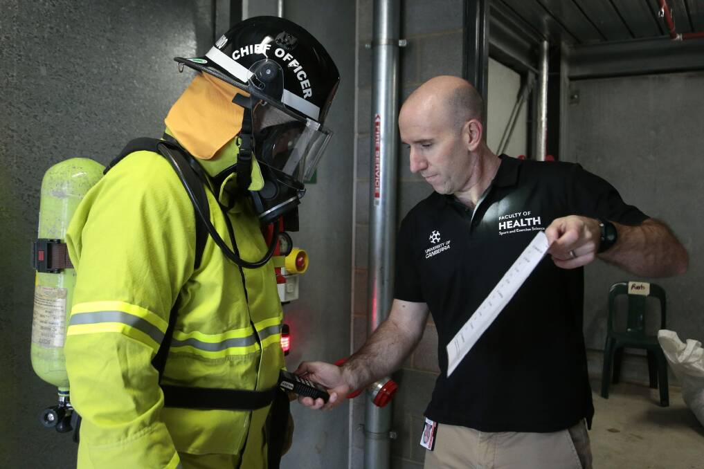   ACT Fire and Rescue chief officer Paul Swain has his core temperature measured by Anthony Walker.  Photo: Jeffrey Chan.
