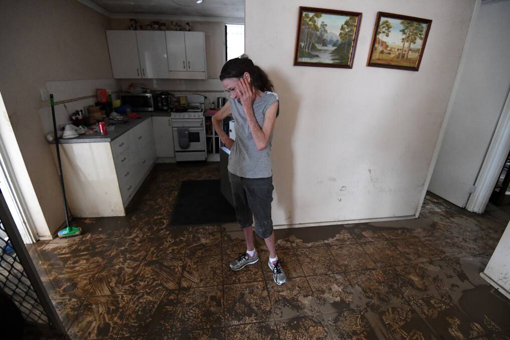 Sue Pollard becomes emotional as she walks around her flood-affected house in the suburb of Hermit Park in Townsville Photo: AAP