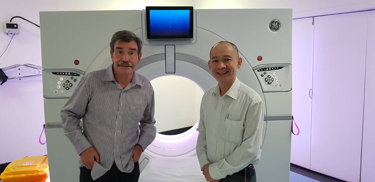 Michael Beatty (left) with Professor Kwun Fong in front of the CT scanner at Prince Charles Hospital. Photo: Stuart Layt