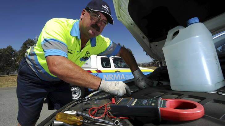 CHECK-UP: NRMA patrolman Jason Venn works to repair an overheated vehicle in Tuggeranong on Monday. Photo: Graham Tidy