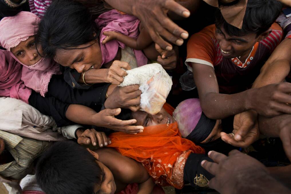 Rohingya Muslims scuffle for donated puffed-rice rations in Kutupalong, Bangladesh. Photo: Bernat Armangue