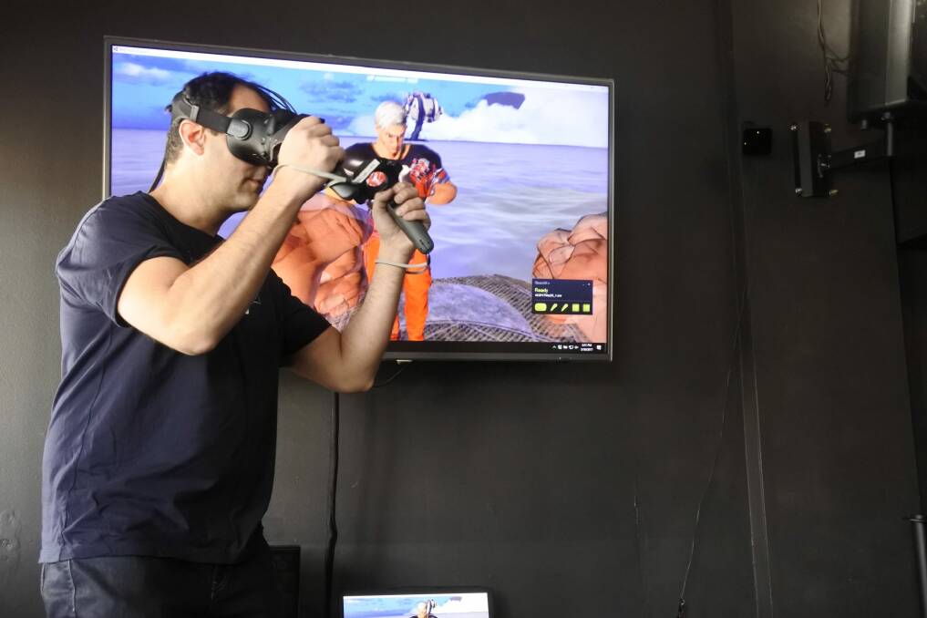 Reload Bar & Games co-owner Ravi Sharma shows off a virtual reality fighting game the bar has developed for future Saturday night tournaments. Photo: Stephen Jeffery