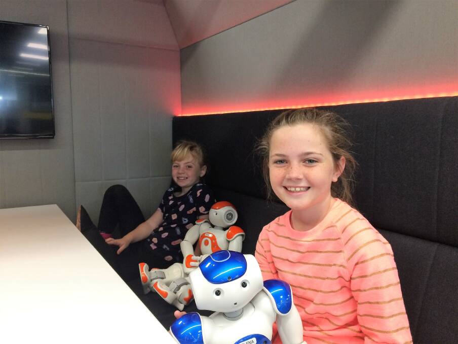 Ella and older sister Ava, 11,  with two of the smaller robots at the centre. Photo: Supplied