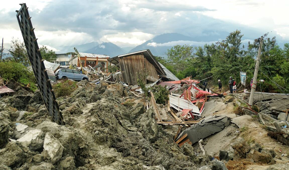 A man looks at the mud chaos left by the broken water embankment in Petobo, a district of Palu.  Photo: Amilia Rosa
