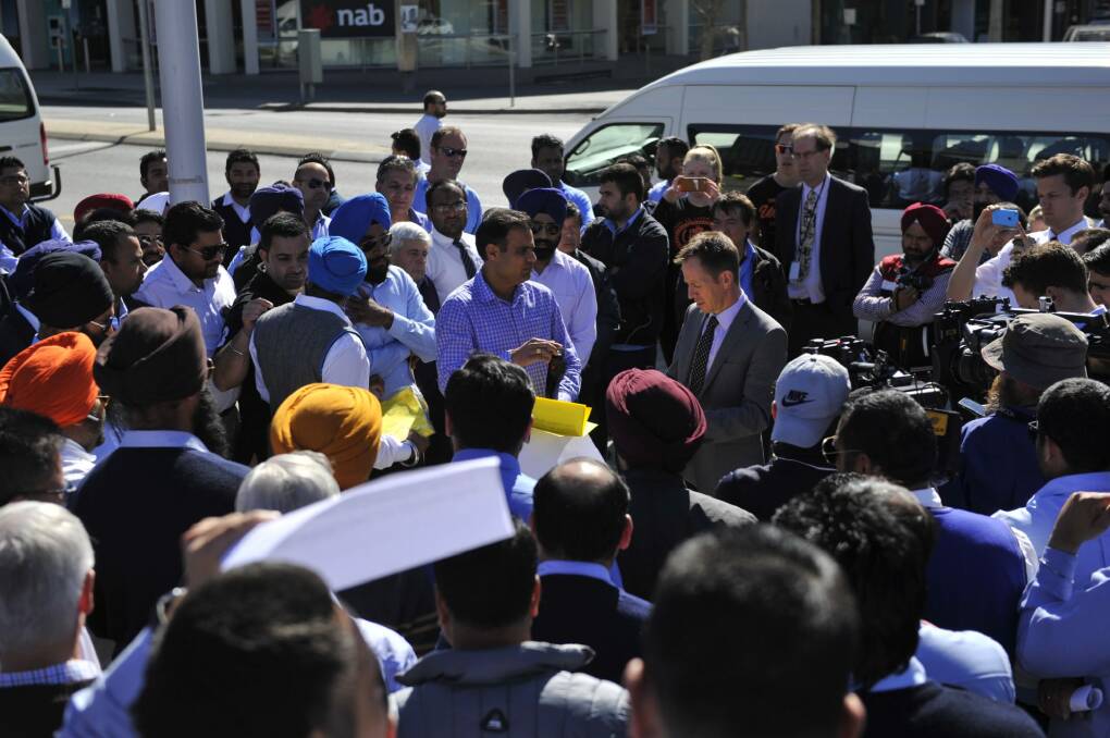 Shane Rattenbury is swamped by taxi owners and drivers. Photo: Jay Cronan