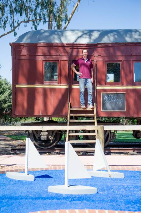 Jason Perkins with one of the 1910 rail carriages he installed to host children's parties. Photo: Jay Cronan