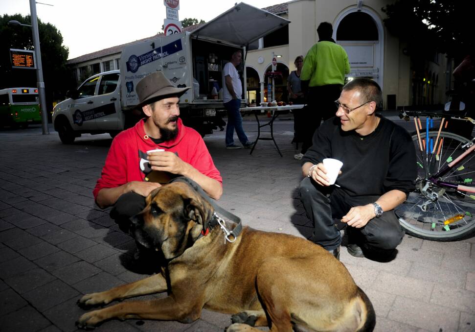 Michael Sobozinski, left, and Randy Booth with dog Bear  use the services provided by the Vinnies Night Patrol van which was set up near Garema Place in Civic.  Photo: Melissa Adams