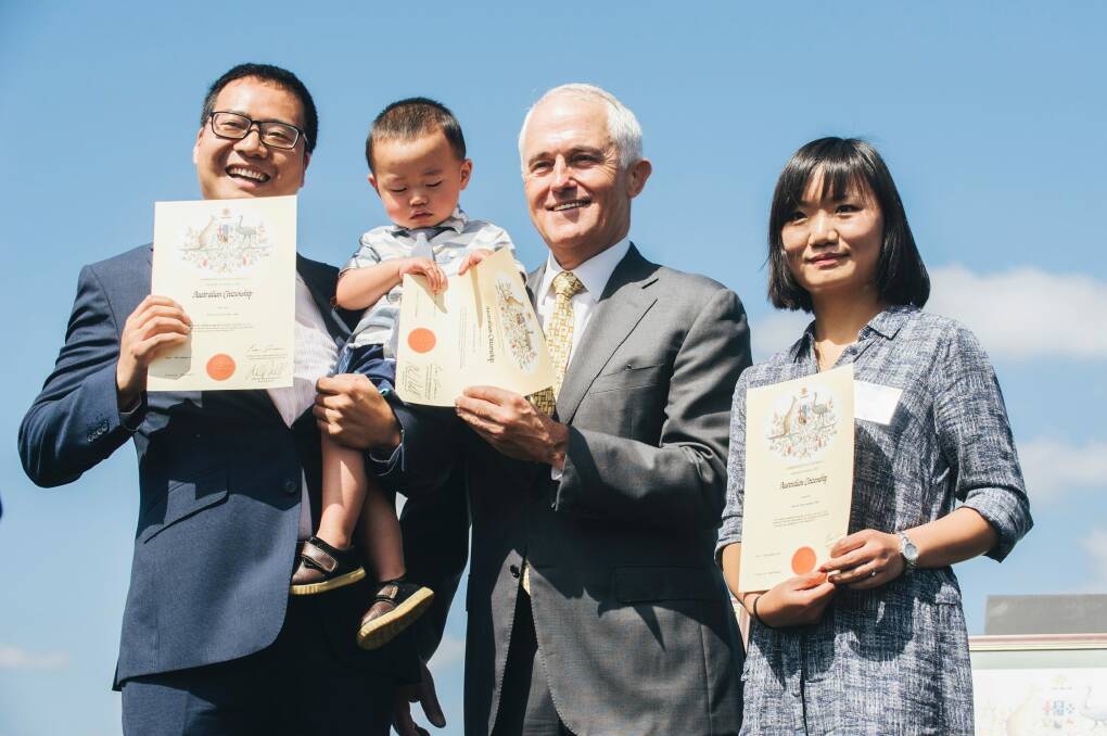 Originally from China, two-year-old Eric Guo was fascinated by his citizenship certificate as he and his parents Rui Guo and Li Wang became Australian citizens in front of Prime Minister Malcom Turbull.  Photo: Rohan Thomson