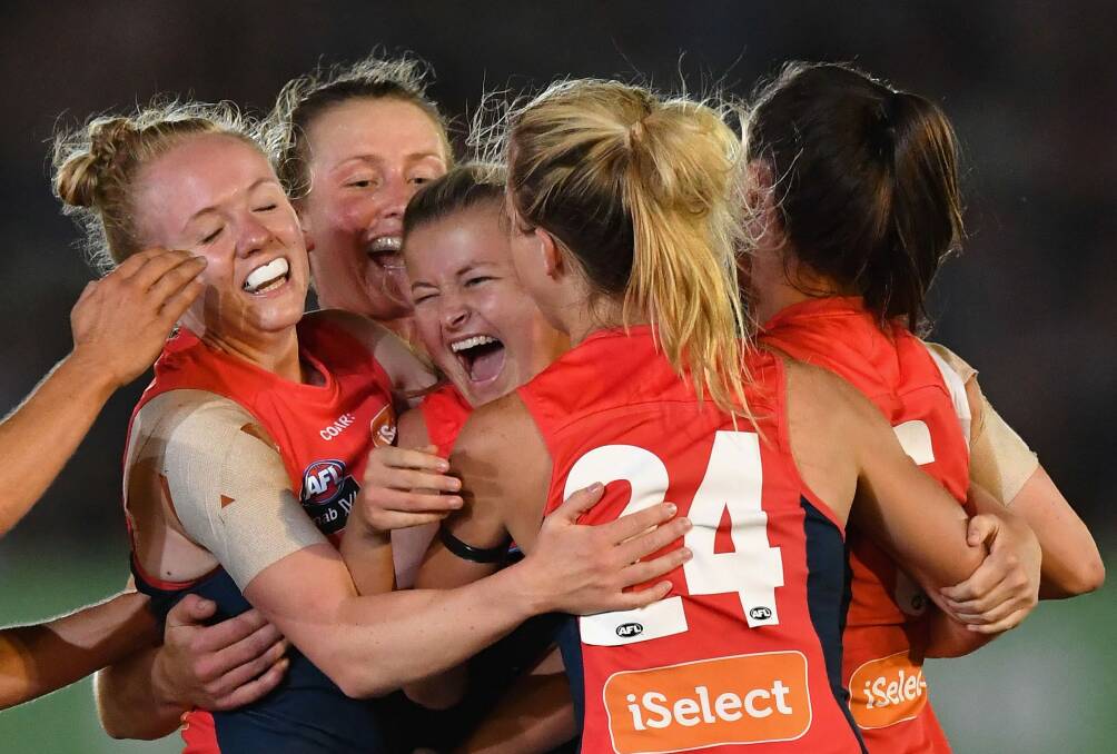 Melbourne celebrate their first ever win in the AFLW on Saturday night. Photo: Quinn Rooney