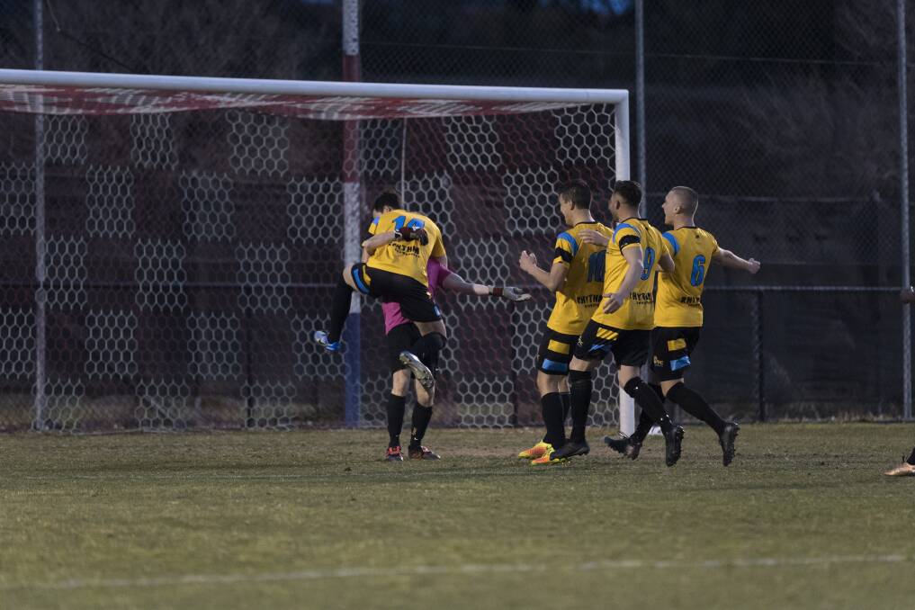 The Tigers celebrate with Cody Nash after saving the match-winning penalty. Photo: Capital Football