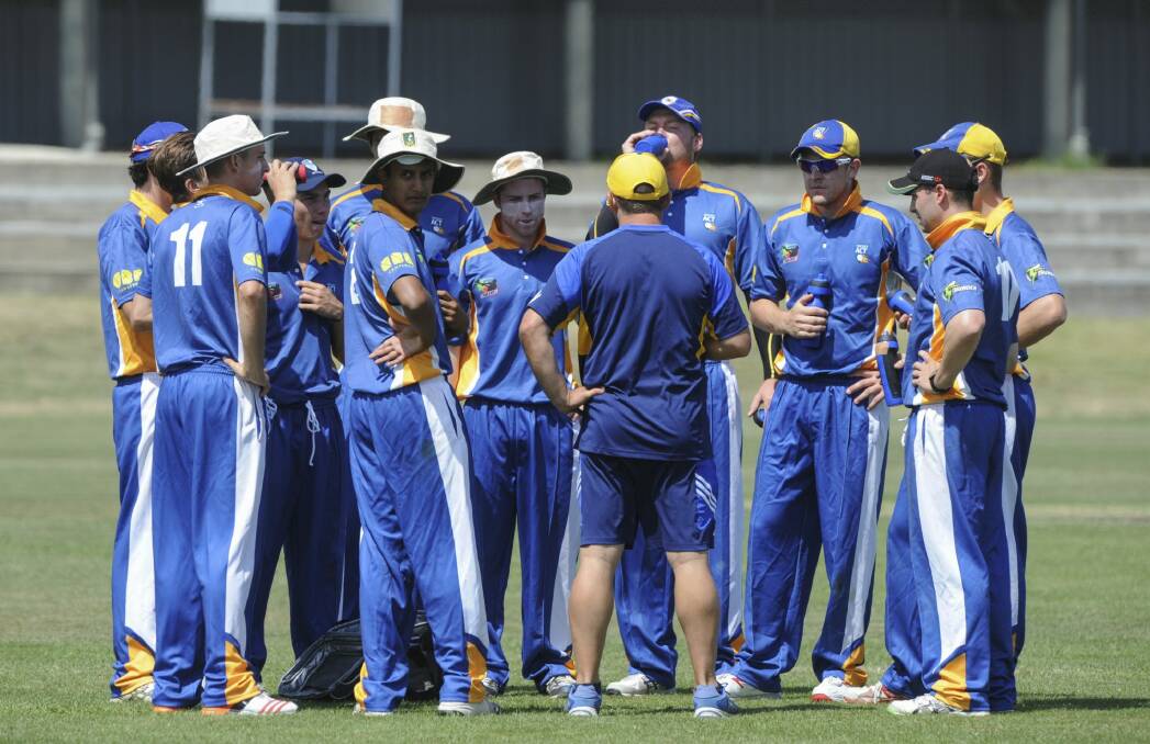 Players take a drinks break and get some words of advice from the coach. Photo: Graham Tidy