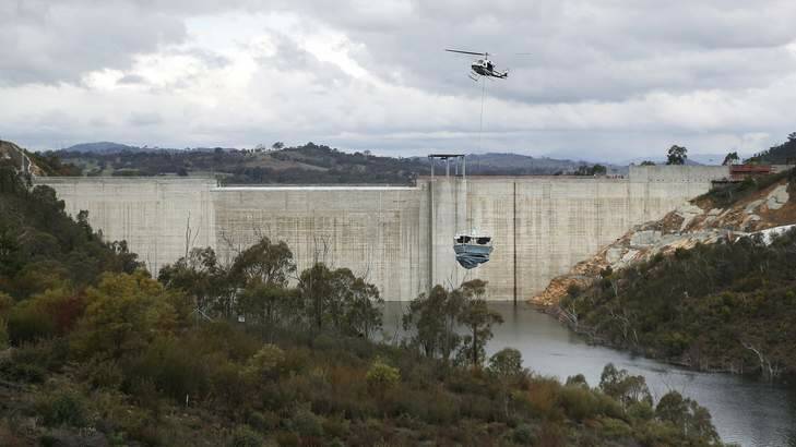 A helicopter lifts a destratification system into position at the Cotter Dam prior to completion. Photo: Jeffrey Chan