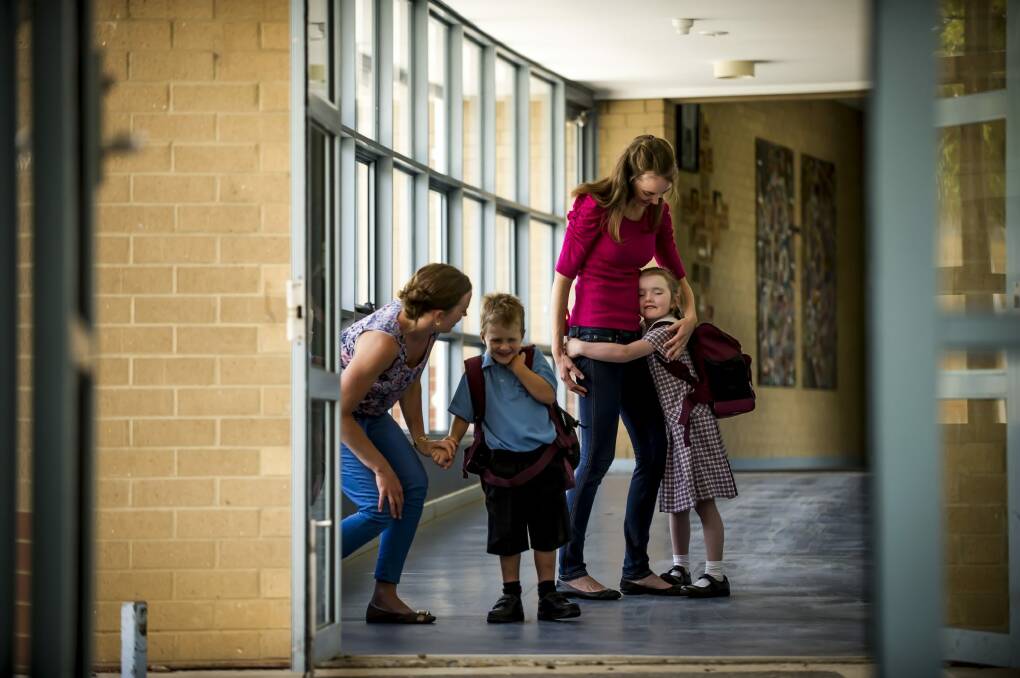 Sisters Michelle Aiken, left, and Alison Bond prepare Cooper and Imogen, both 5, for their first day of school at St Francis of Assisi Primary - the same school they attended as children.  Photo: Karleen Minney
