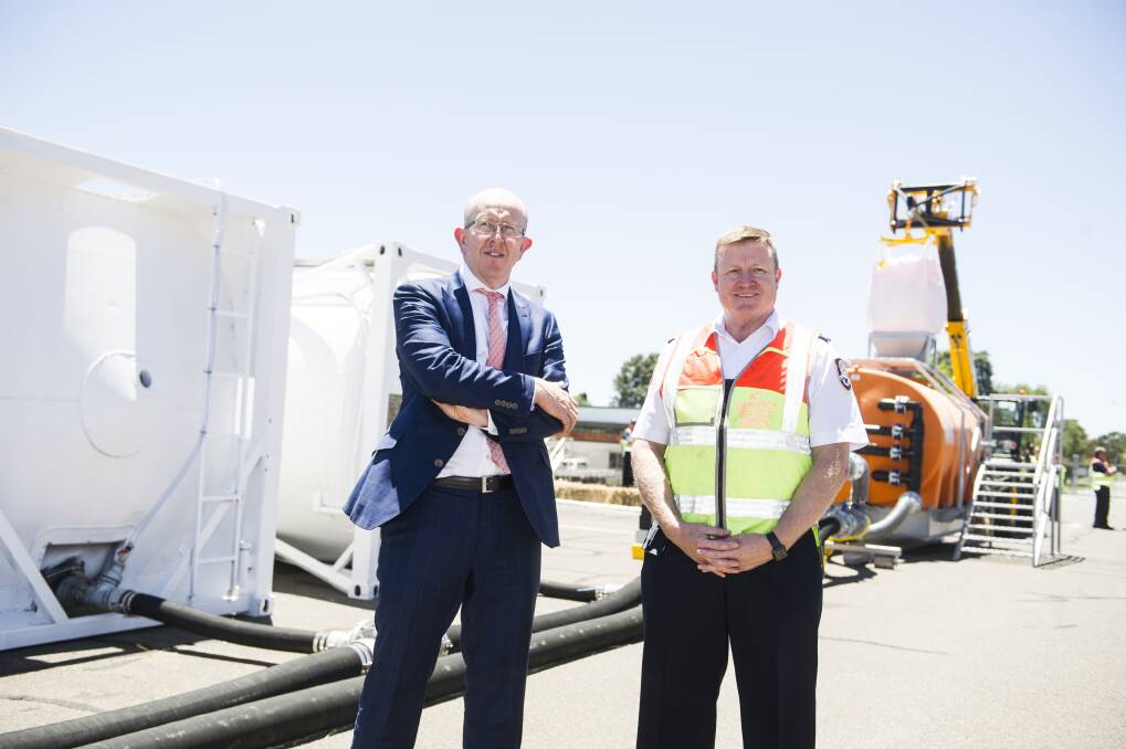 Canberra Airport managing director Stephen Byron and ACT Emergency Services Agency commissioner Dominic Lane stand in front of the the fire retardant filing station at ACT's first fire bombing airbase. Photo: Dion Georgopoulos